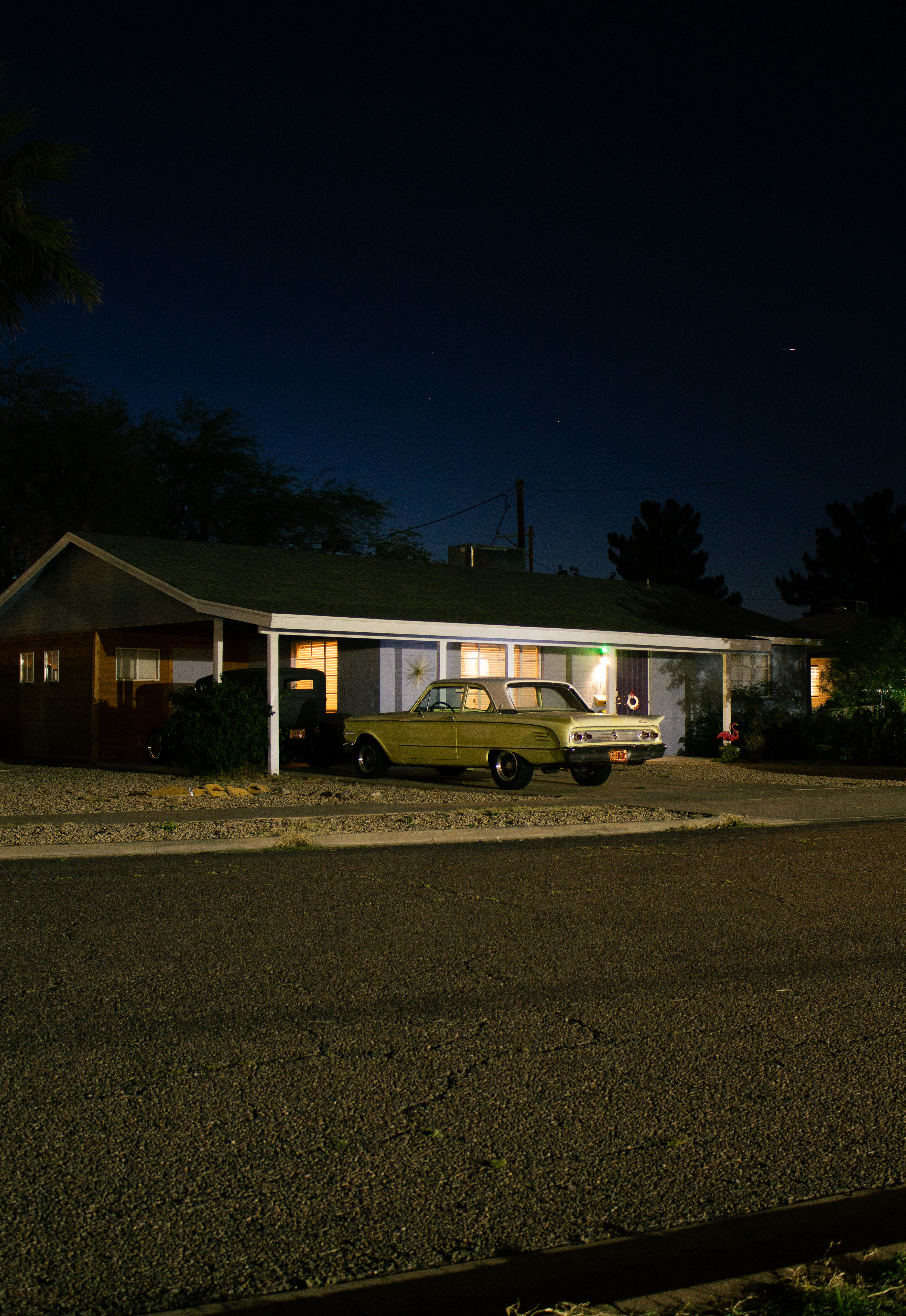 A lone house with a vintage car bathed in ominous ambient light.